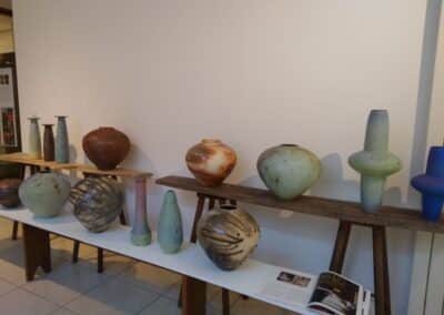 Une rangée de petits vases et de sculptures en céramique