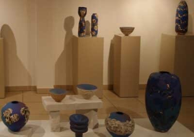 Une sélection de céramiques bleues et brunes disposées sur des socles