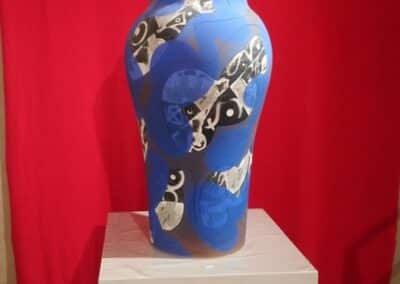 Un grand vase bleu décoré de motifs noirs et blancs