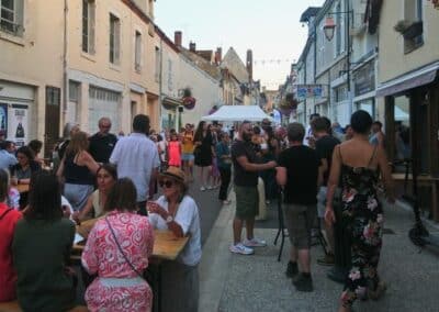 Les visiteurs se retrouvent autour des terrasses et des stands dans une rue