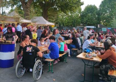 Festivaliers assis autour de tables de pique-nique