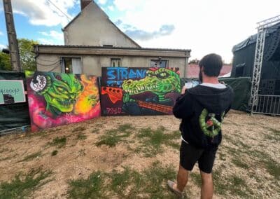 Festivalier devant une fresque colorée du site