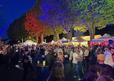 Grand public sous les arbres éclairés en bleu et violet
