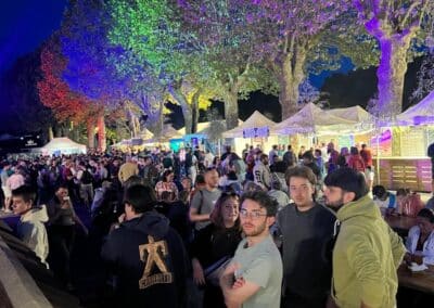 Public sous les arbres illuminés en bleu
