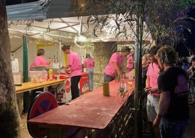 Bénévoles en tee-shirt rose sous un chapiteau