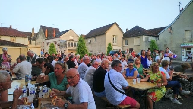 Les participants partagent un repas sur une place animée
