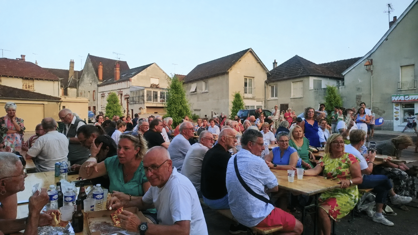 Les participants partagent un repas sur une place animée