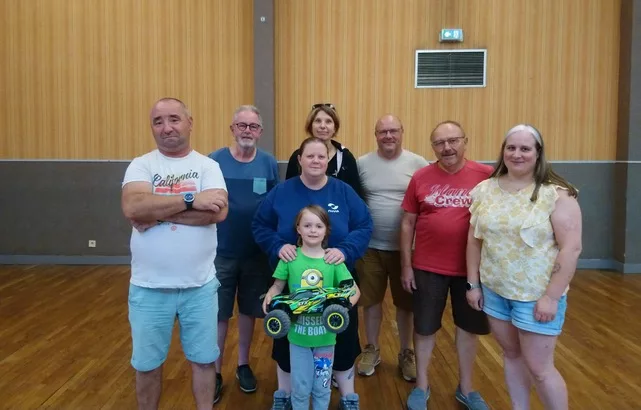 Membres de l’association À fond les manettes réunis avec une enfant et sa voiture radiocommandée