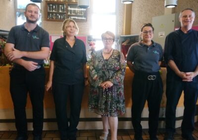 L’équipe du restaurant pose avec une représentante de l’Amicale des retraités