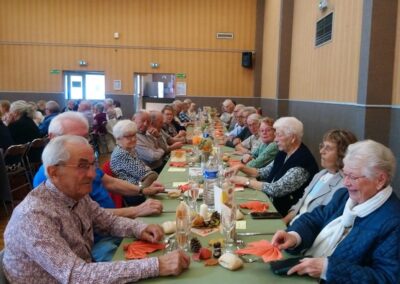 Des retraités sourient autour d’une longue table dressée