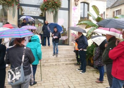 Des habitants rassemblés sous la pluie sur le parvis de la mairie